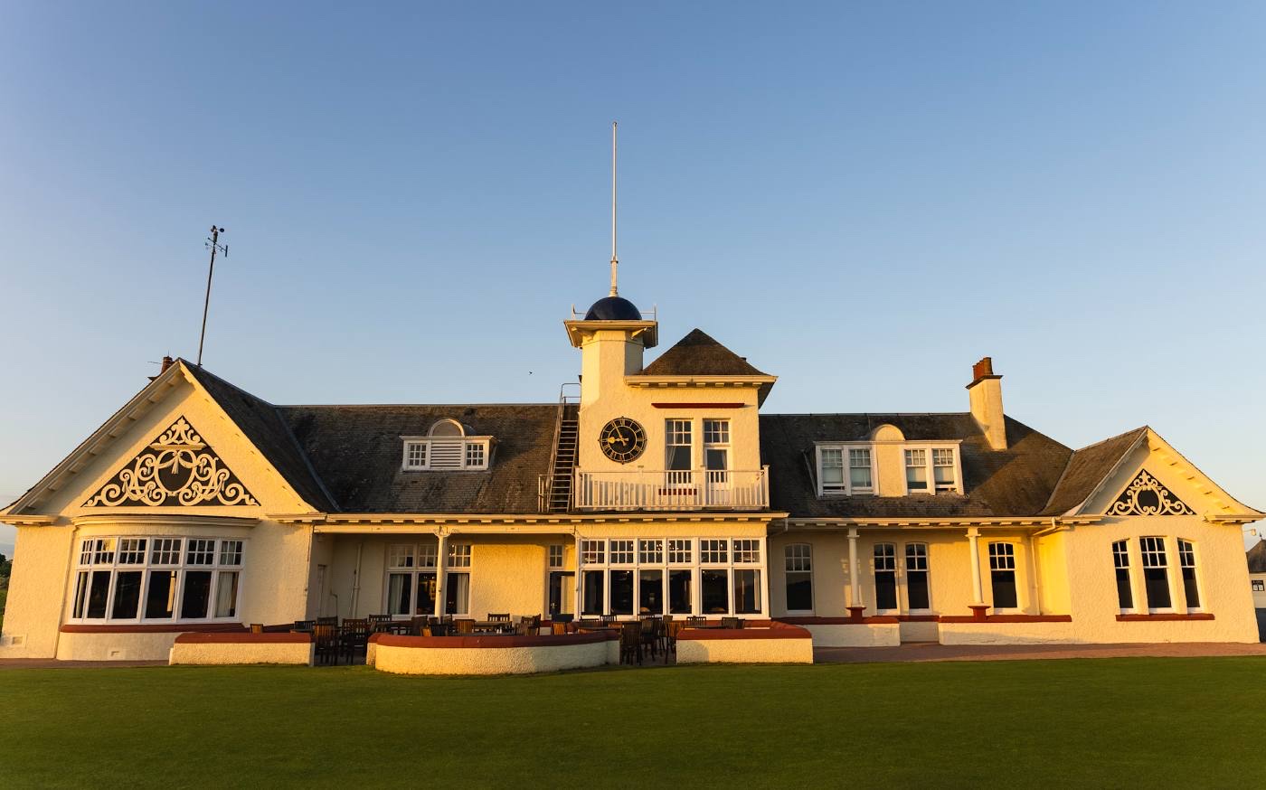 The Panmure clubhouse in evening light, straight on, with the terrace and its furniture in front