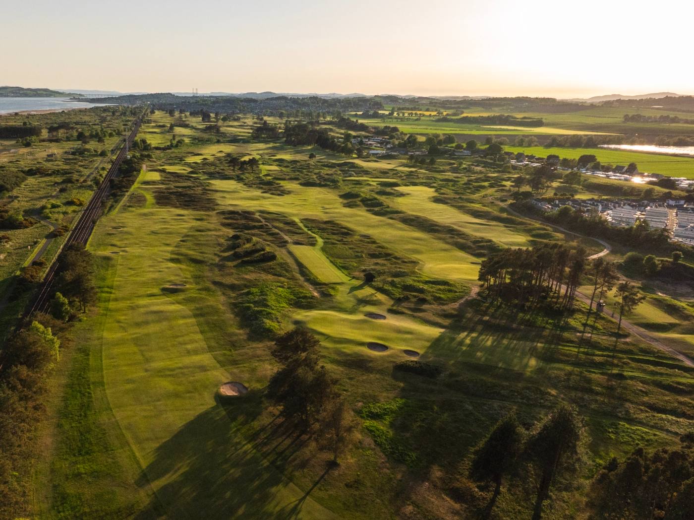 Aerial view of the links running beside the Dundee railway line, the coast beyond