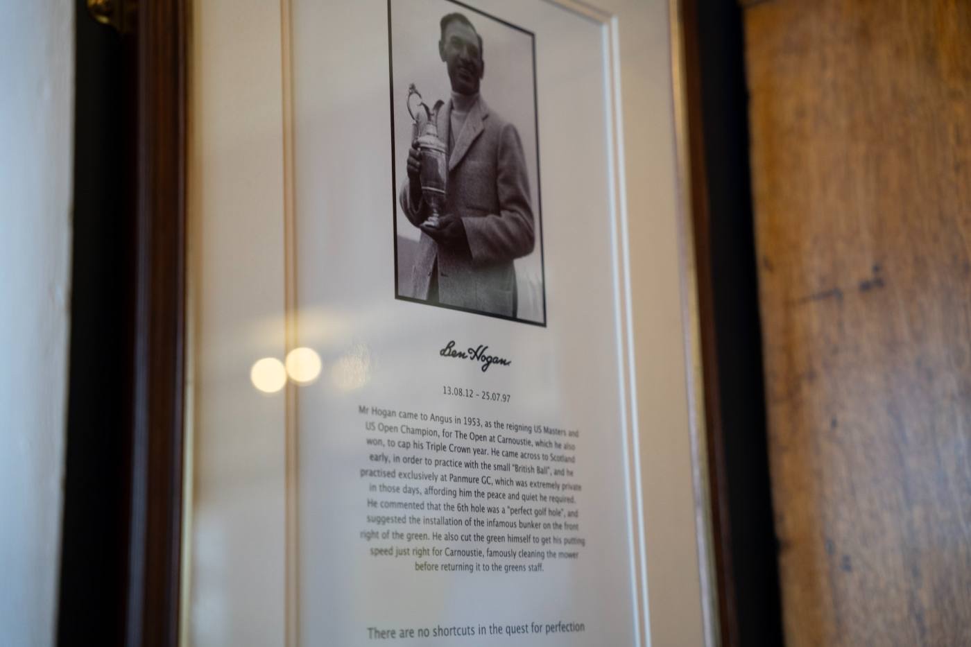The framed Hogan tribute in the clubhouse: a photograph of him holding the Claret Jug, his signature beneath it, and an account of the fortnight he spent at Panmure in 1953