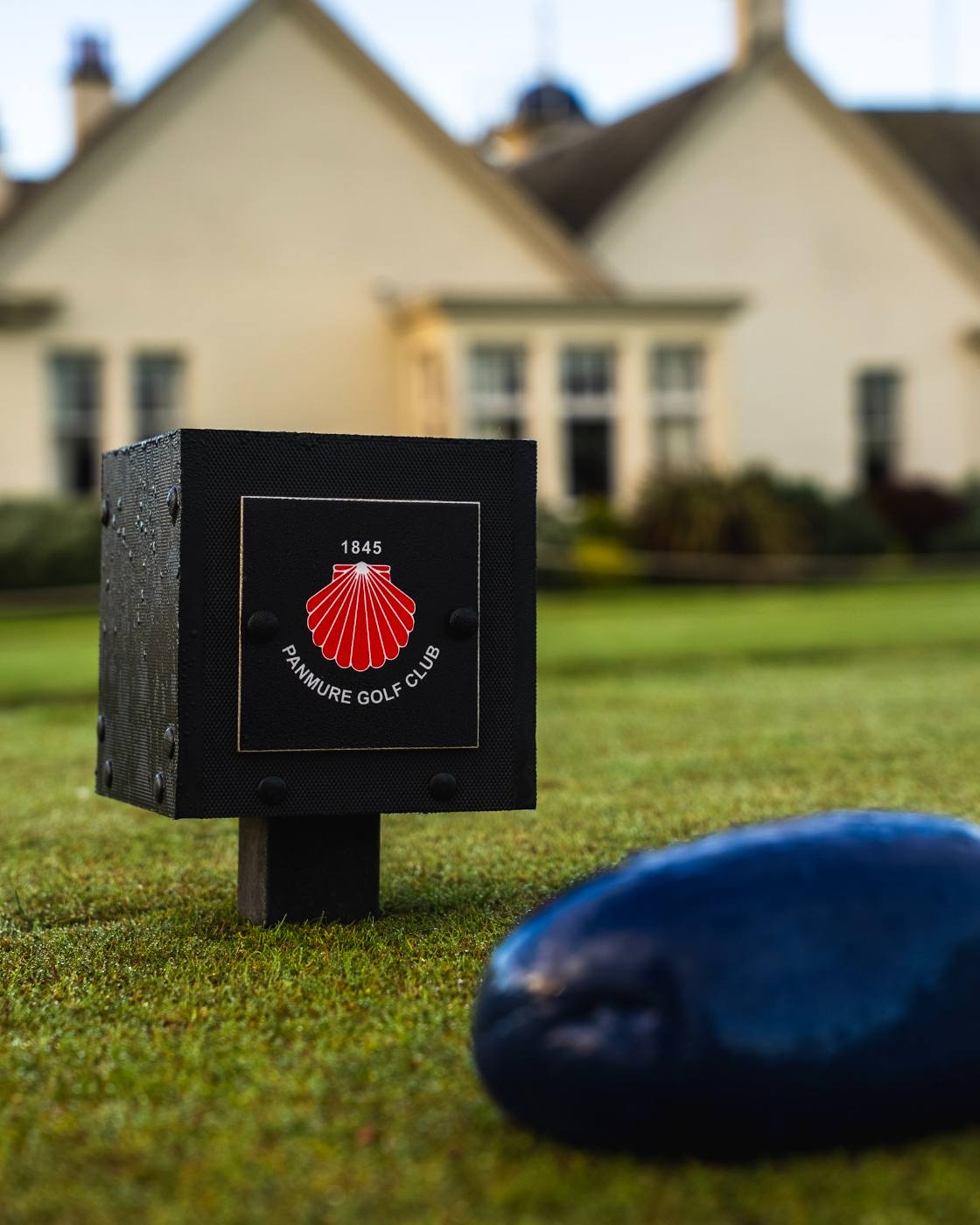 A tee marker carrying the Maule scallop shell.